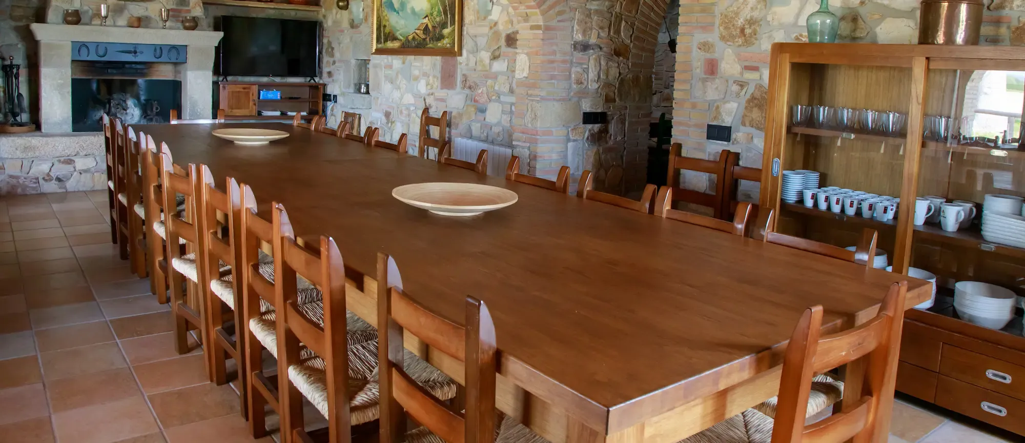 Gran comedor con mesa de madera y chimenea