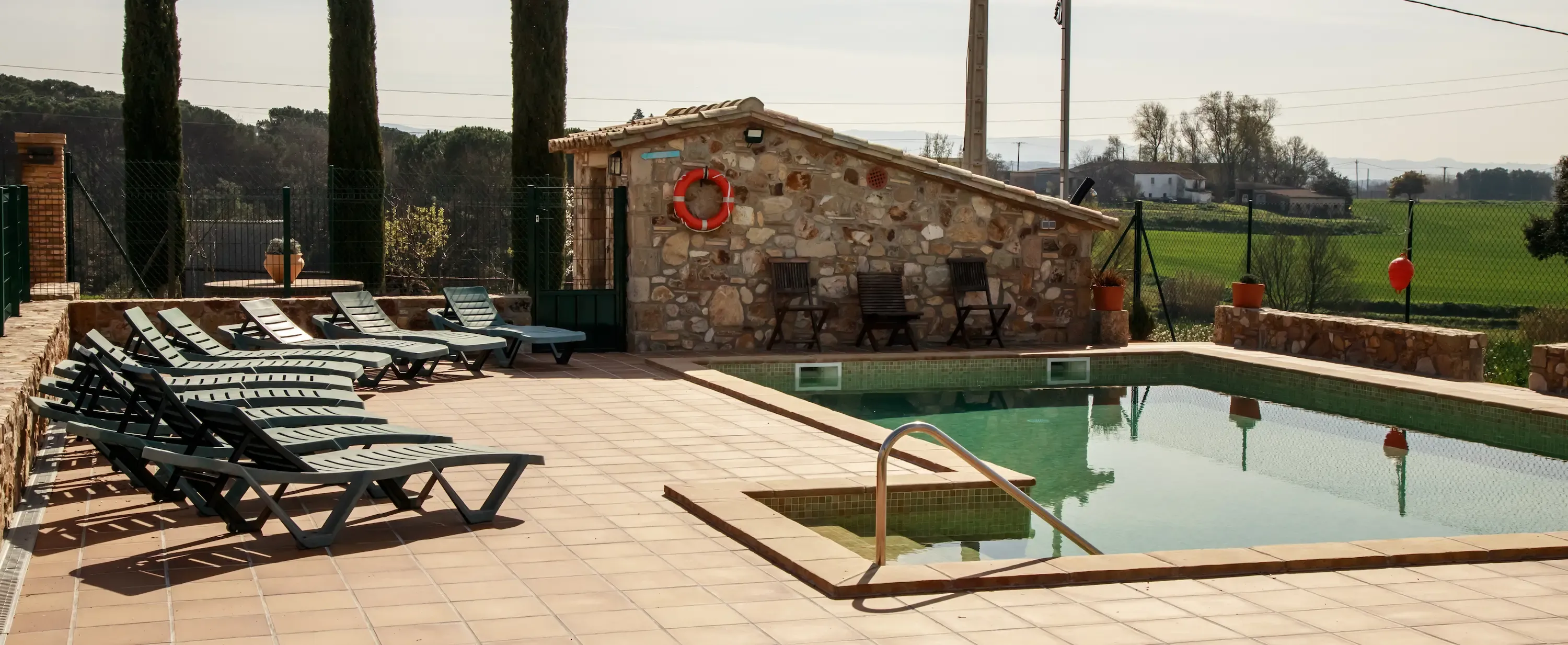 Piscina rodeada de terraza de baldosas terracota